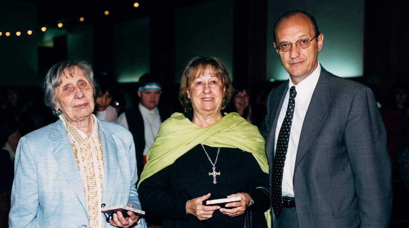 Archivo histórico IPSI: tres referentes de la institución posan en un acto formal, dos mujeres y un hombre con saco gris y corbata.